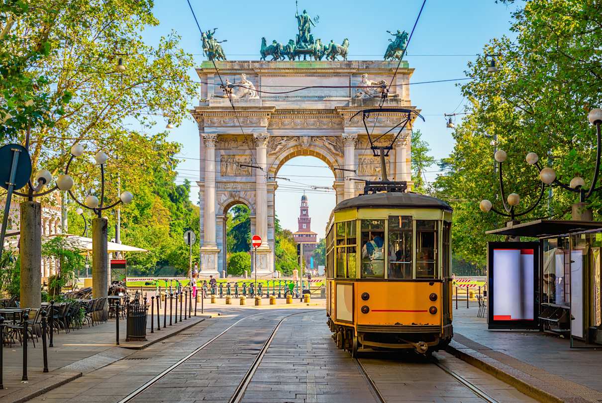 Yellow vintage tram in front of the Arco della Pace (Peace Arch) in Milan, Italy