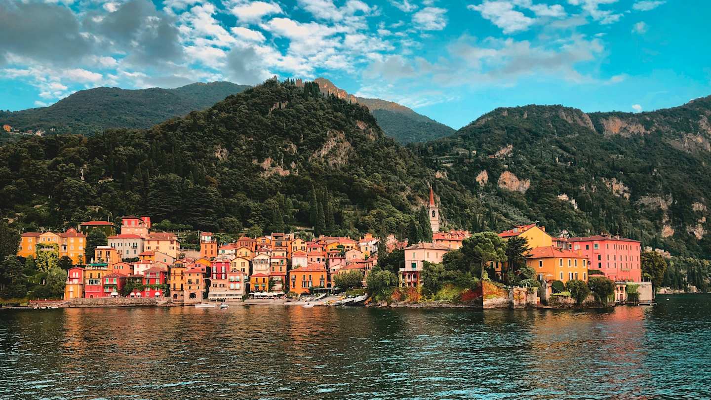 Ferry boat with cars and passengers crossing Lake Como with Alps in the background, Como, Italy