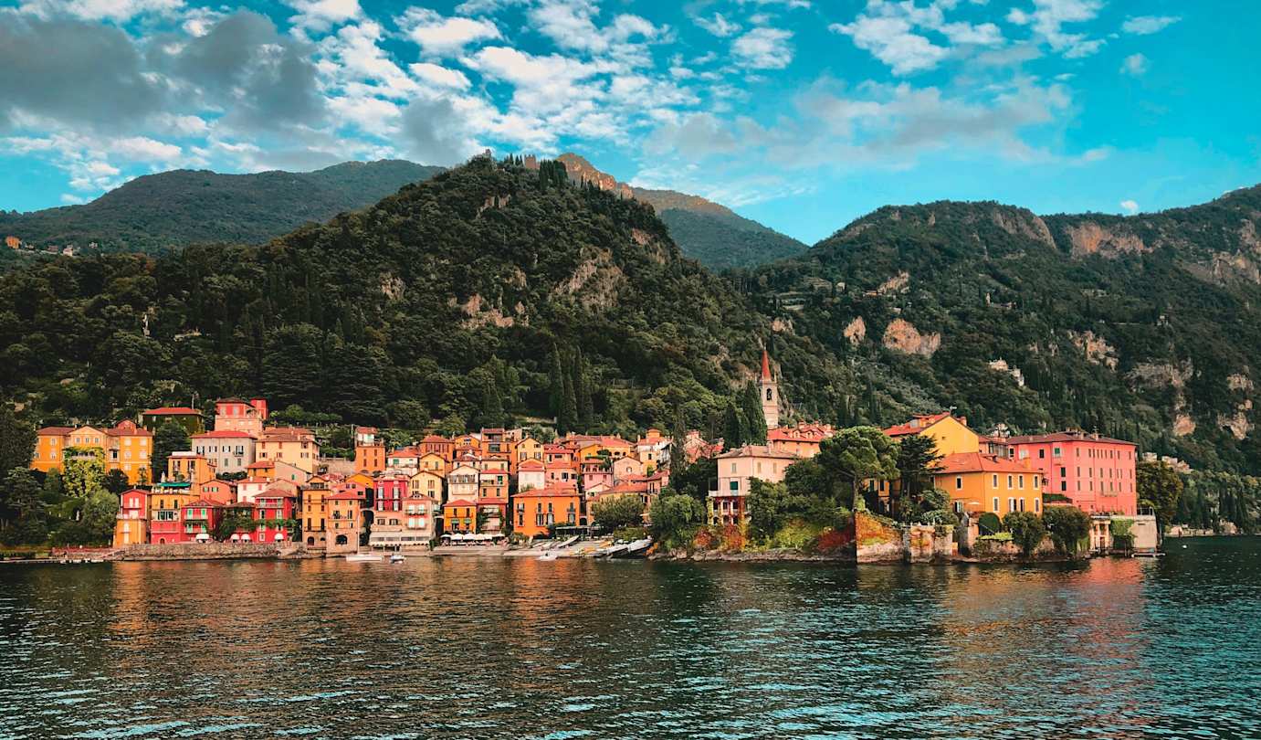 Ferry boat with cars and passengers crossing Lake Como with Alps in the background, Como, Italy