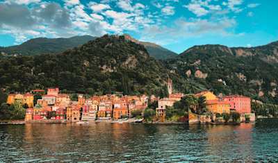 Ferry boat with cars and passengers crossing Lake Como with Alps in the background, Como, Italy