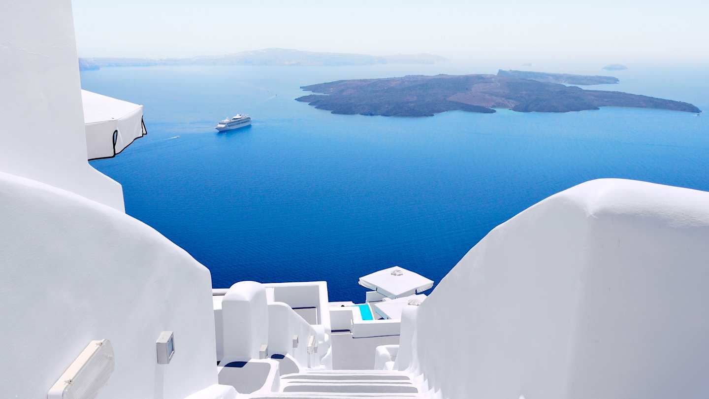 A view of white walls and steps overlooking the sea from high up, Santorini, Greece