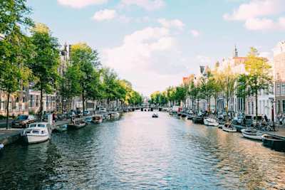A canal filled with docked boats alongside terraced buildings, Amsterdam, Netherlands