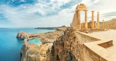 A view of the Acropolis of Lindos on a cliff above the blue sea, Rhodes, Greece