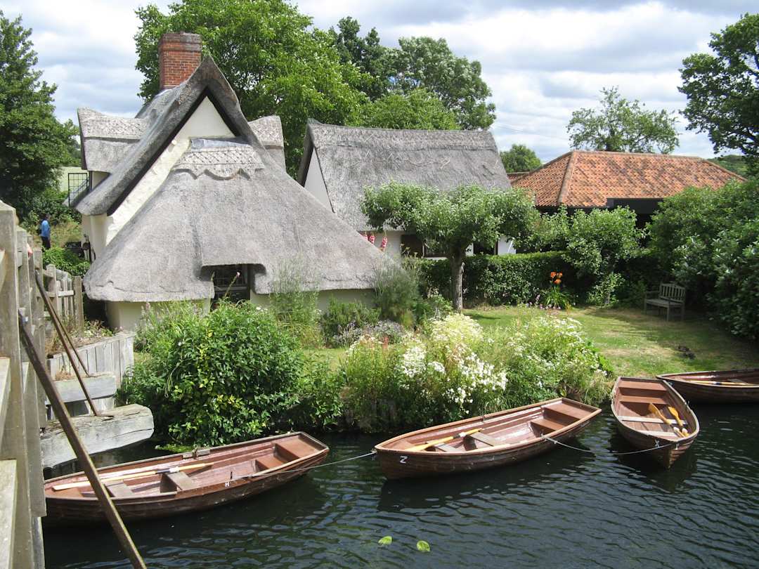 Cottages and boats at the National Trust Centre, Flatford, Dedham Vale, Suffolk