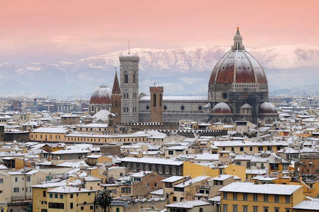 Beautiful winter cityscape of snow-covered Cathedral of Santa Maria del Fiore with mountains in the background, Florence, Italy