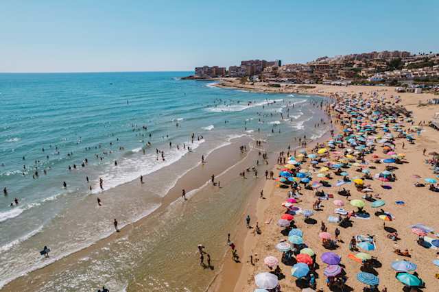 Aerial view of people swimming and relaxing on Torre La Mata beach in Torrevieja on a sunny summer day, Alicante
