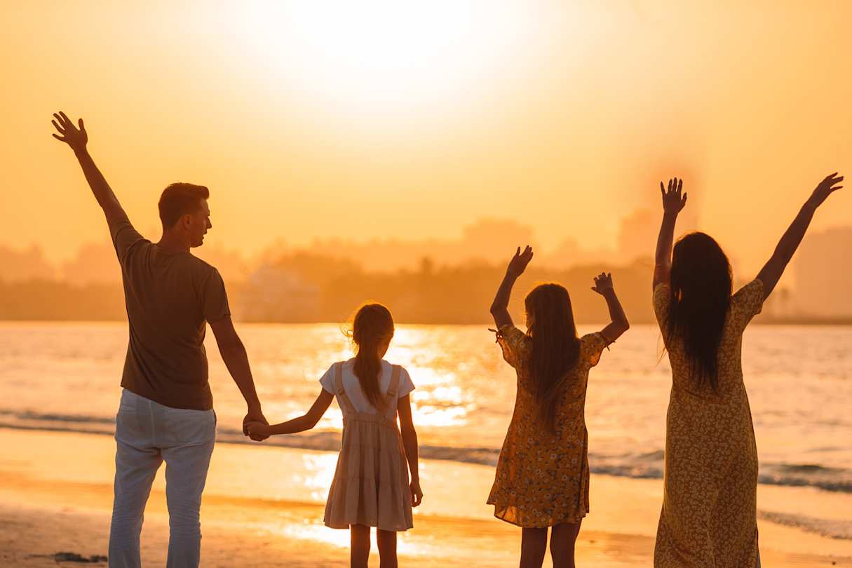 A young family enjoying the sunset from a sandy beach in Dubai, UAE