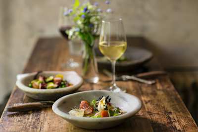 Table with plates of food and glasses of wine