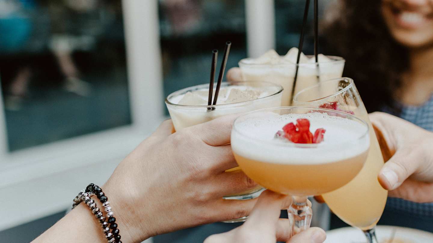 Hands raising glasses of cocktails