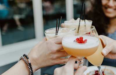 Hands raising glasses of cocktails