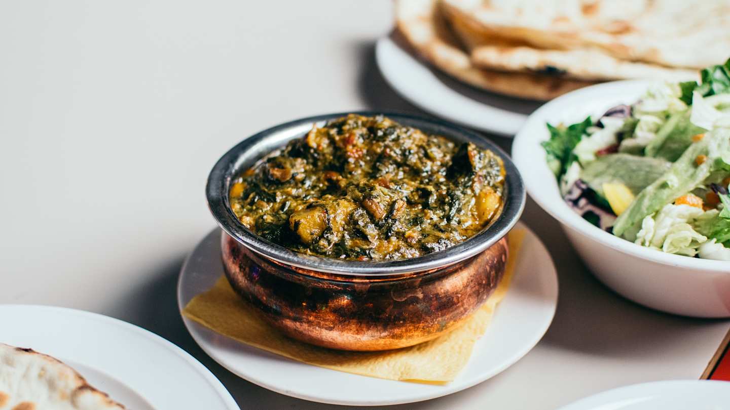 Aloo palak dish with breads and salads
