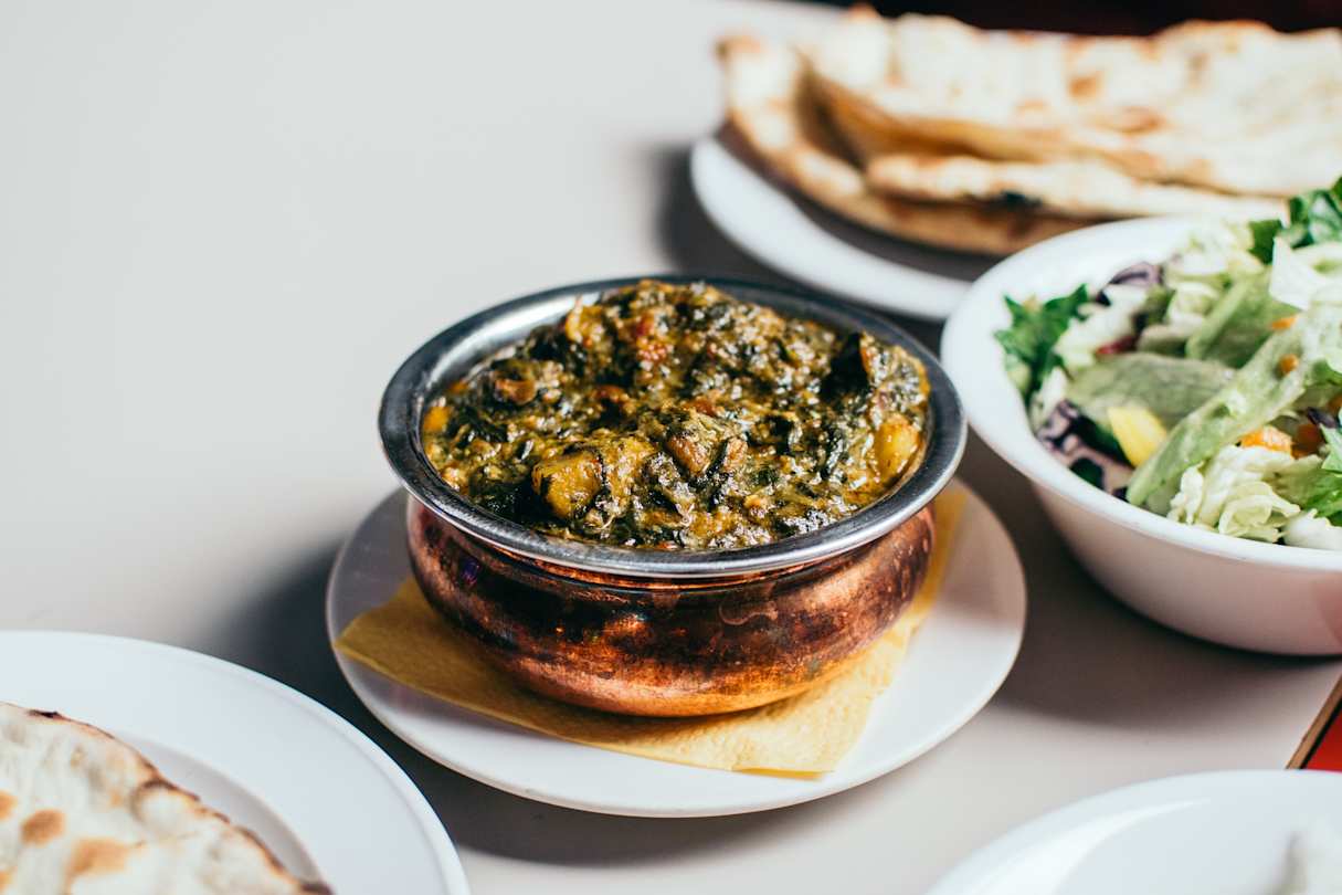 Aloo palak dish with breads and salads