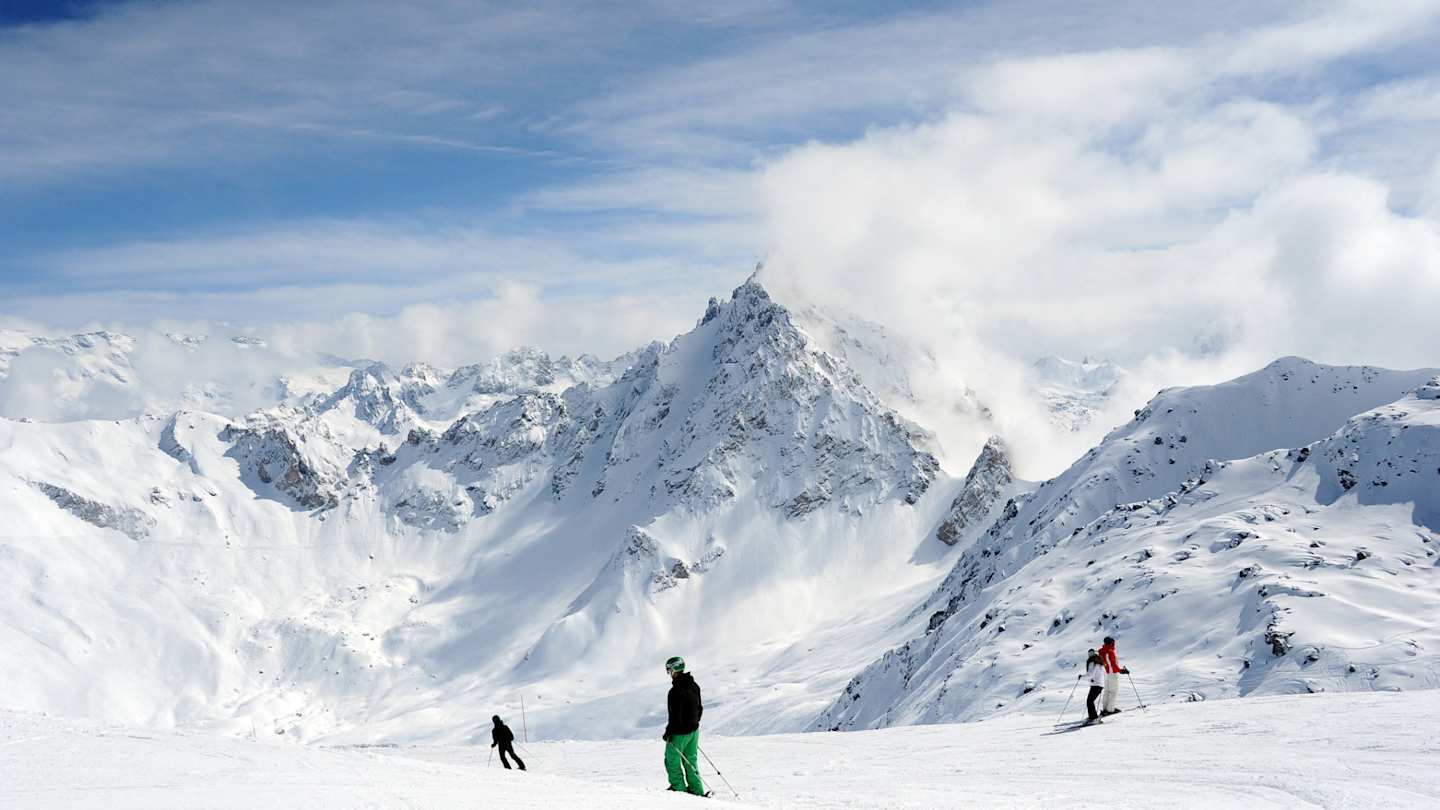 People skiing on large snowy mountains in the French Alps, France