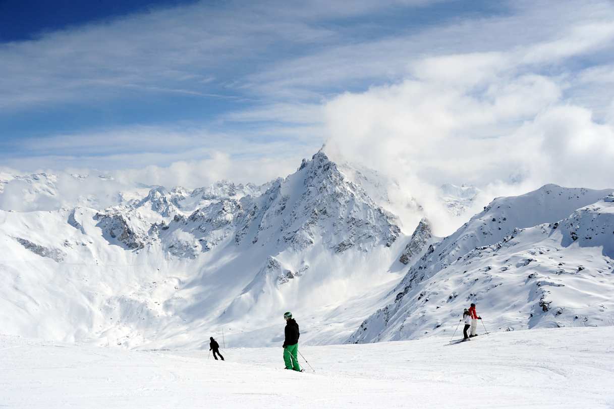 People skiing on large snowy mountains in the French Alps, France