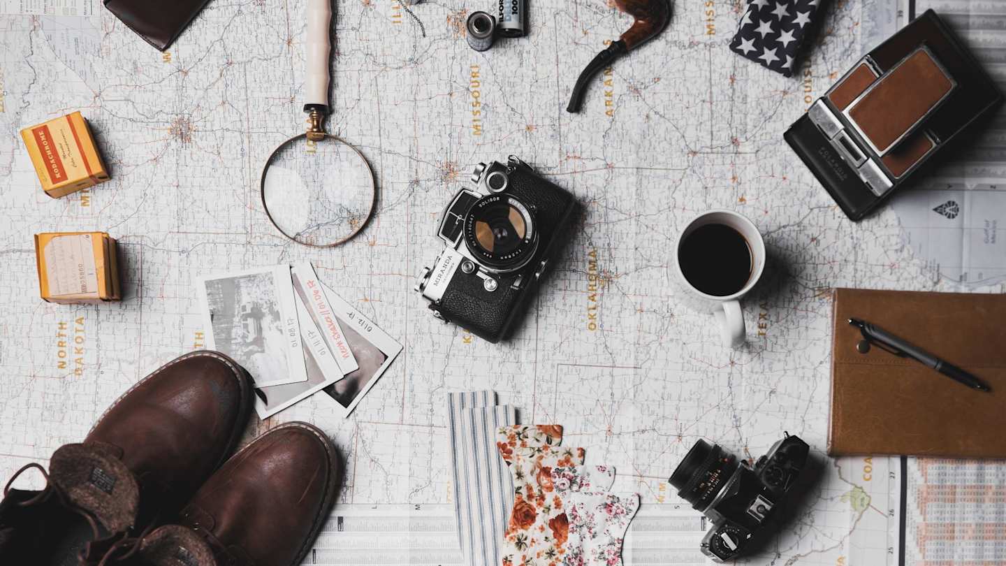 A collection of travel equipment around a camera on a large map
