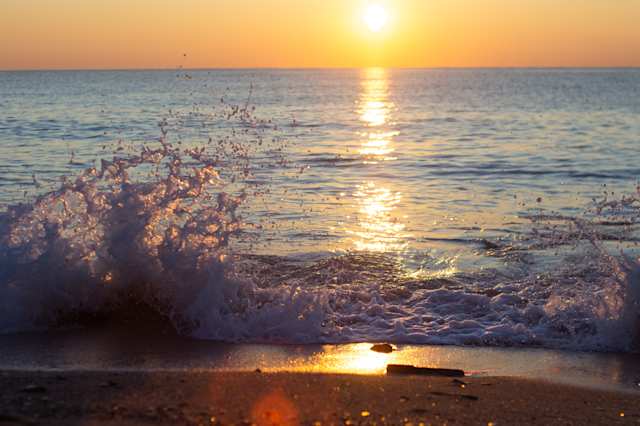 A close up of a wave crashing on a beach at sunrise in Barcelona, Spain