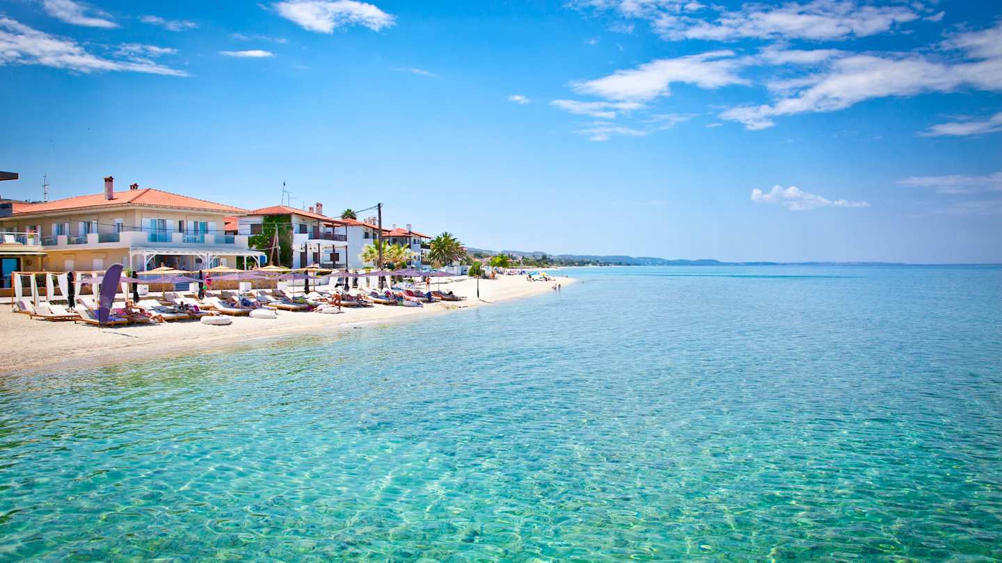 A view of a small beach from in the clear blue sea on a sunny day in Halkidiki, Greece