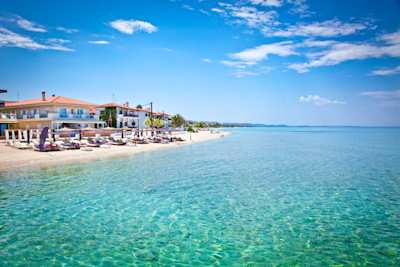 A view of a small beach from in the clear blue sea on a sunny day in Halkidiki, Greece