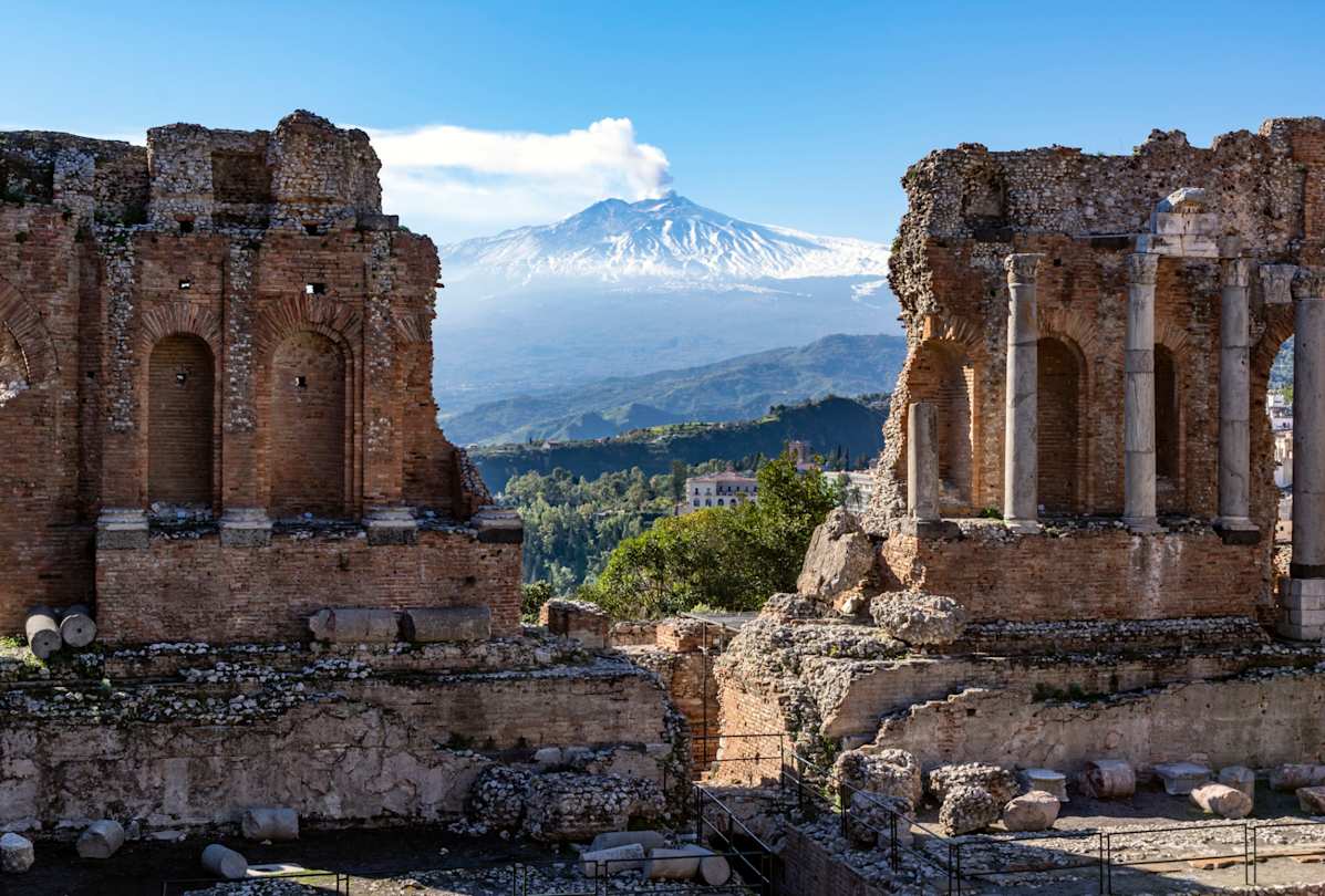 View of Mount Etna through ruins of ancient amphitheatre, Sicily