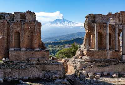 View of Mount Etna through ruins of ancient amphitheatre, Sicily