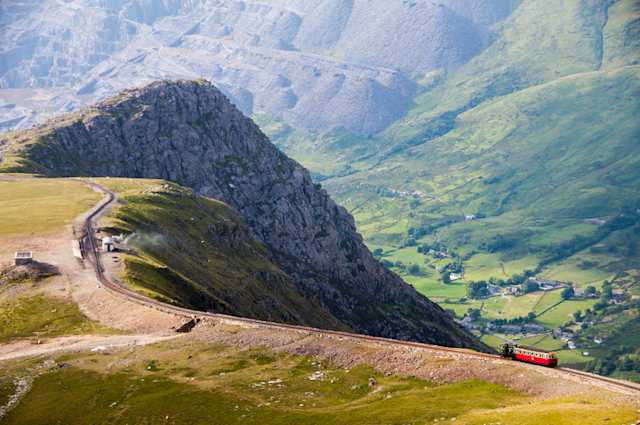 Train descending from the summit of Snowdon Mountain on the mountain railway, with Llanberis Valley and Dinorwig Slate Quarry in the distance, Wales