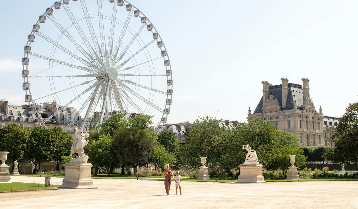 Child walking along path lined with colourful flowers