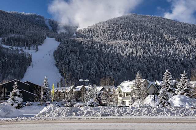 Snow-covered cabins at the bottom of a tall snowy mountain at a Telluride Ski Resort, Colorado, USA