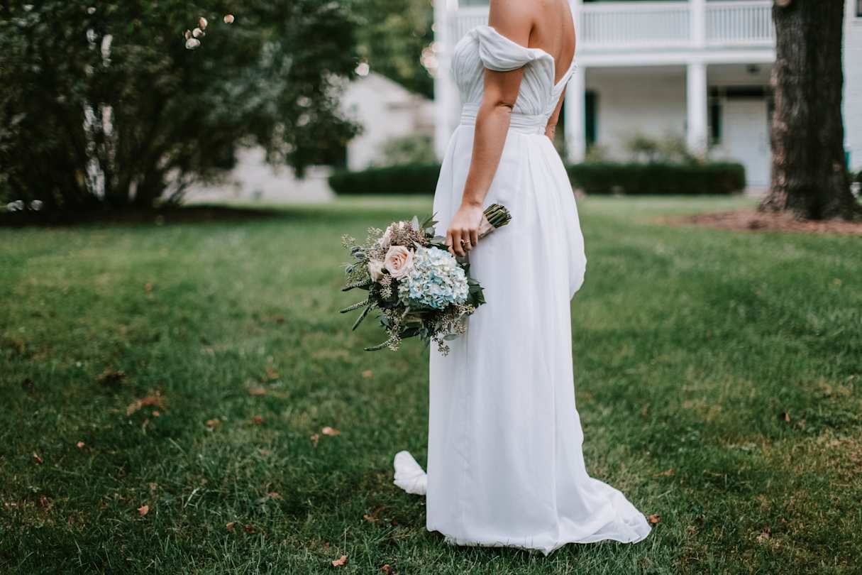 Bride holding bouquet of flowers in wedding dress
