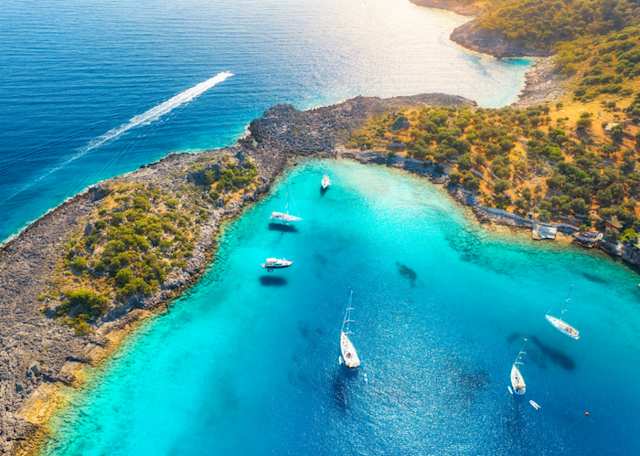An aerial view of white boats on clear blue water in Turkey