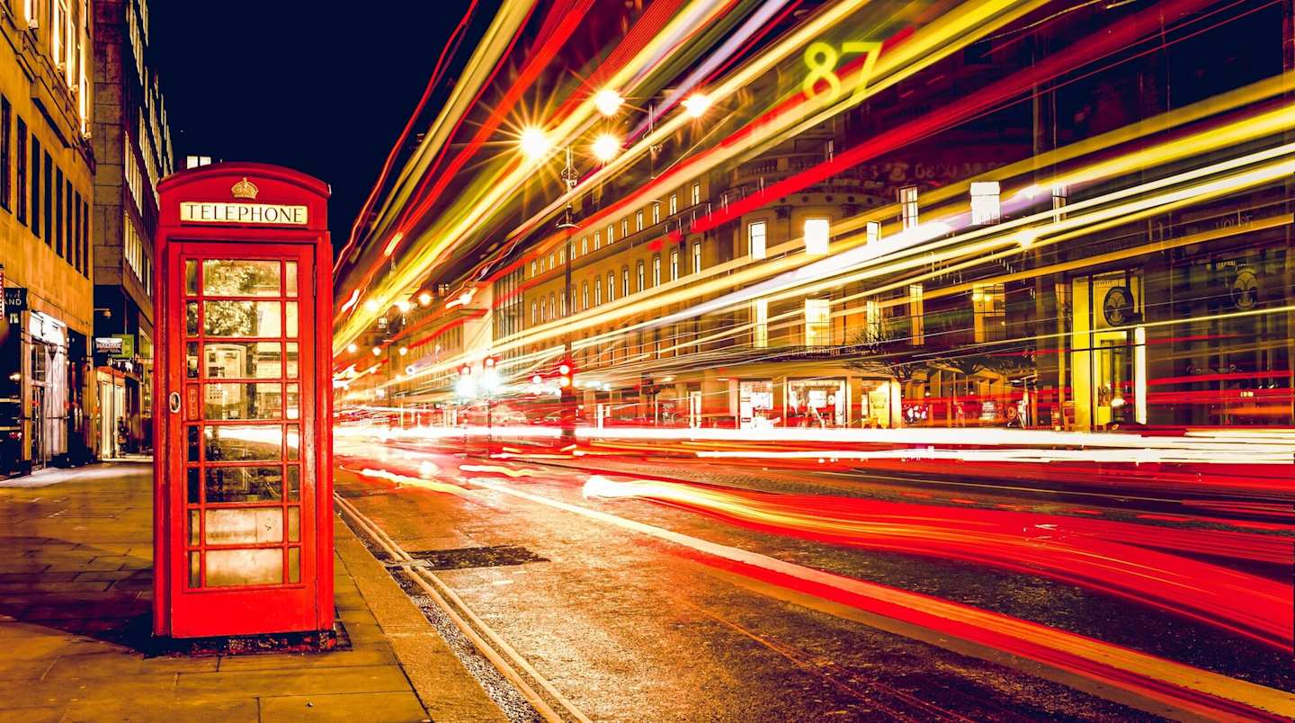 London street lit up at night with red phone box