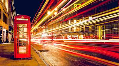 London street lit up at night with red phone box