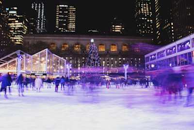 Ice skating around a Christmas tree in Bryant Park, New York, USA