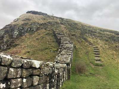 A close up view of Hadrian's Wall on a green hill on a misty day, Northumberland, England, UK