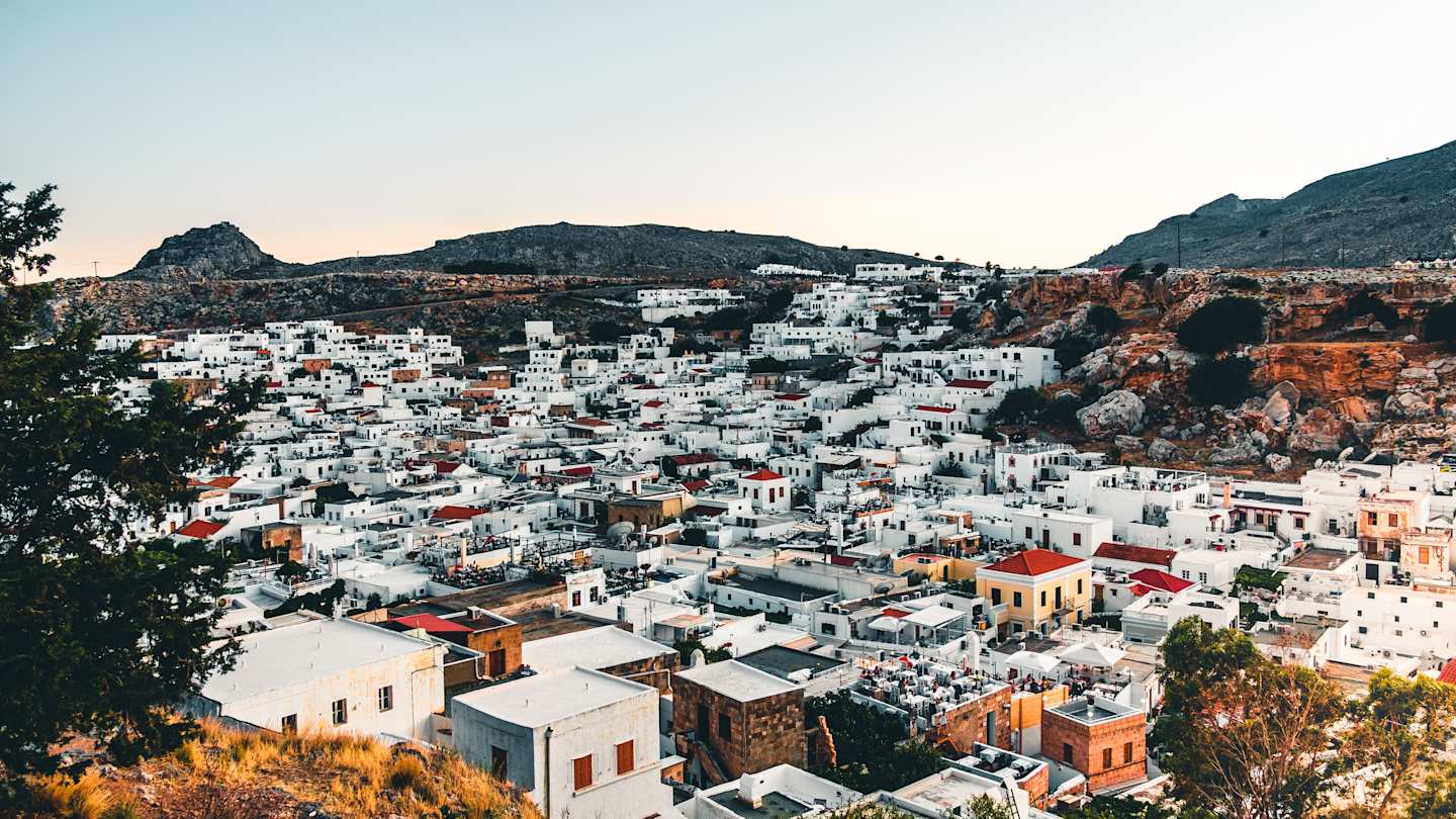 An aerial view over white buildings and distant mountains in Rhodes, Greece