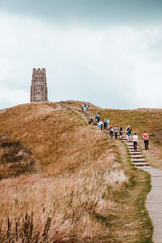 People walking up a hill to Glastonbury Tor, Somerset, England, UK