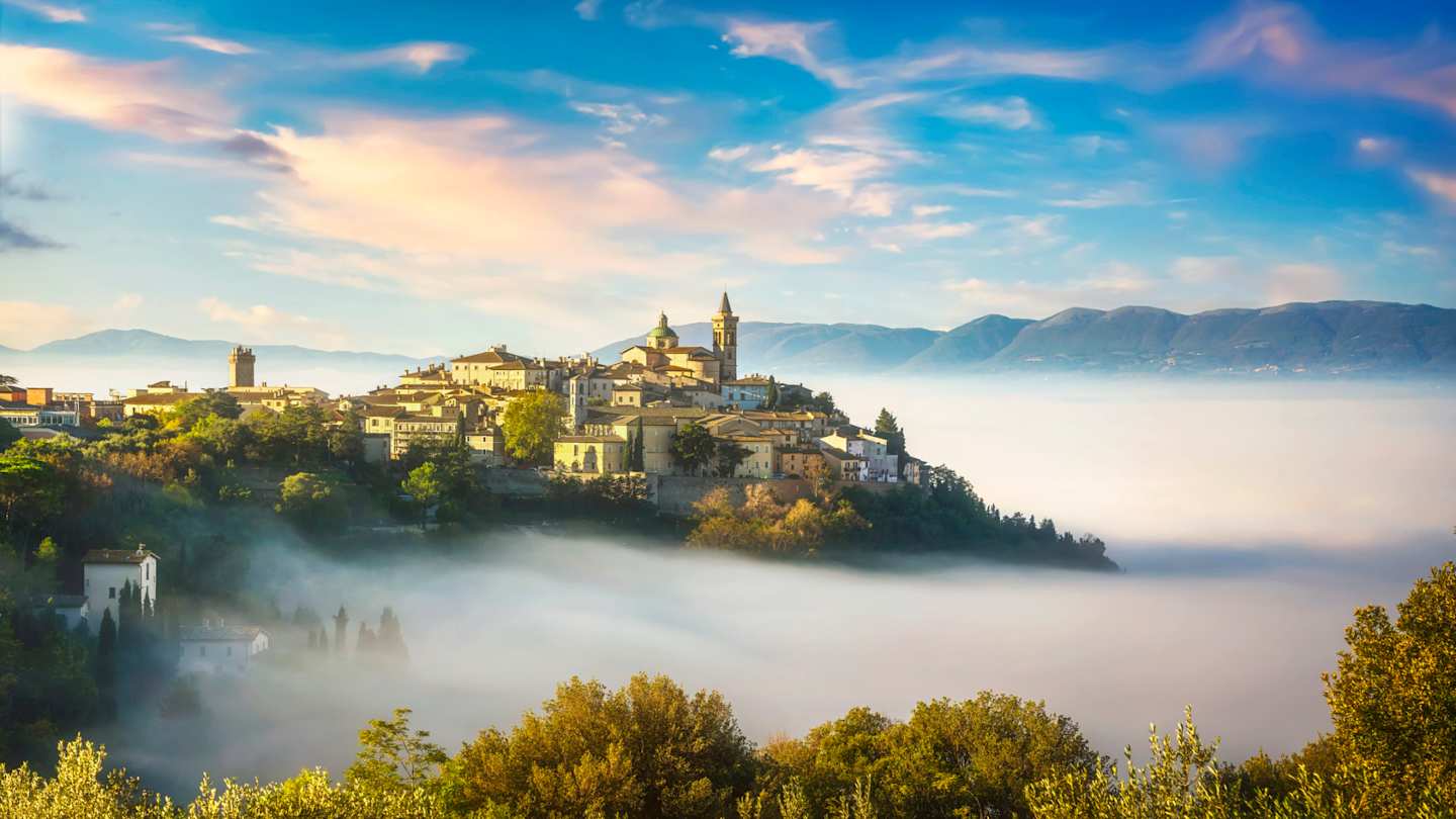 Scenic view of the village of Trevi taken on a foggy morning with mountains in the background, Umbria, Italy