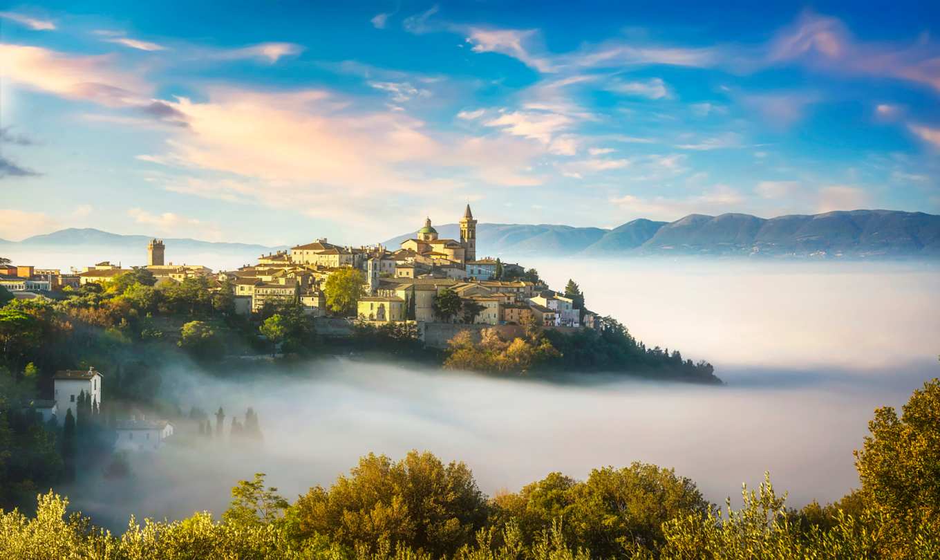 Scenic view of the village of Trevi taken on a foggy morning with mountains in the background, Umbria, Italy