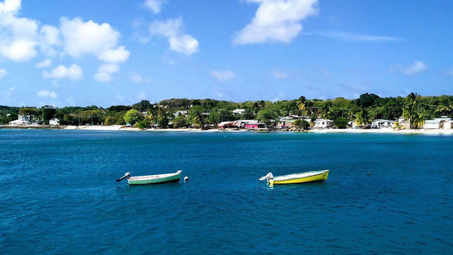 Two empty boats on the sea by the shore in Barbados