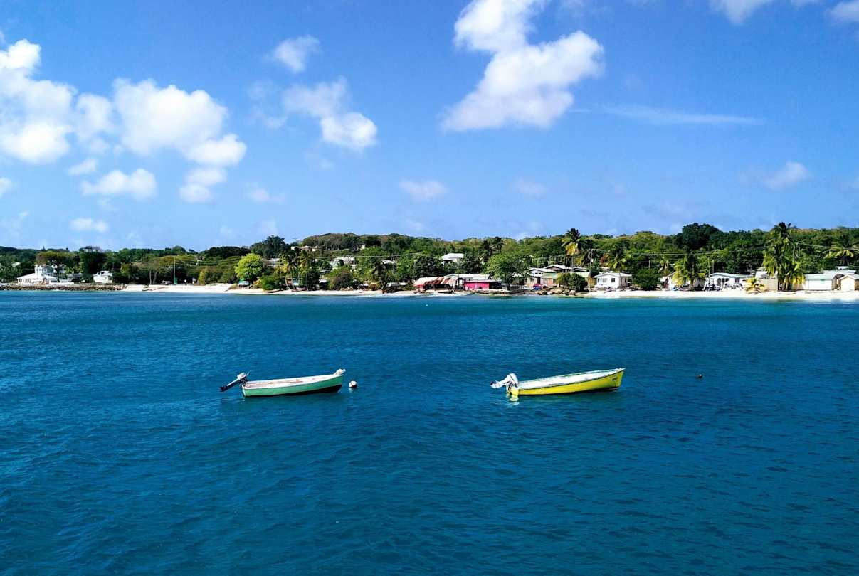Two empty boats on the sea by the shore in Barbados