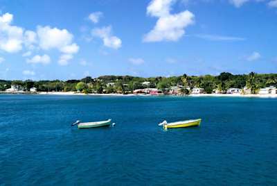 Two empty boats on the sea by the shore in Barbados