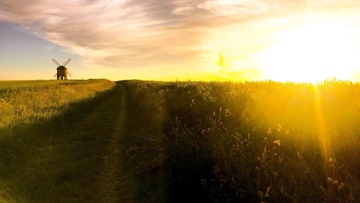 A large field with a distant windmill at sunset in Royal Leamington spa, Warwickshire, England, UK