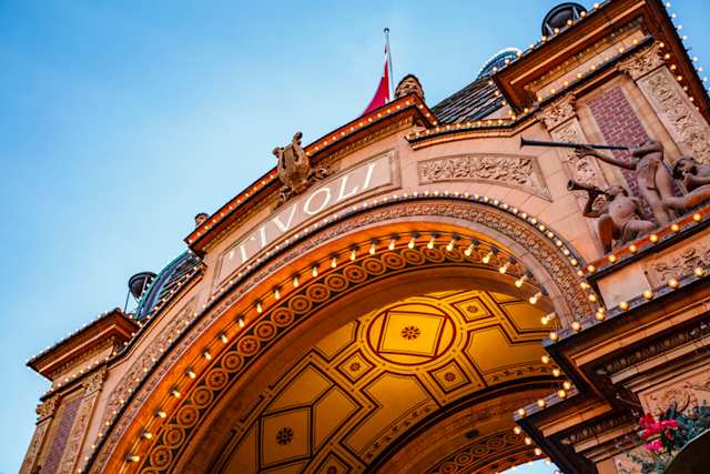 Entrance gate of Tivoli Gardens lit up at dusk, Copenhagen, Denmark