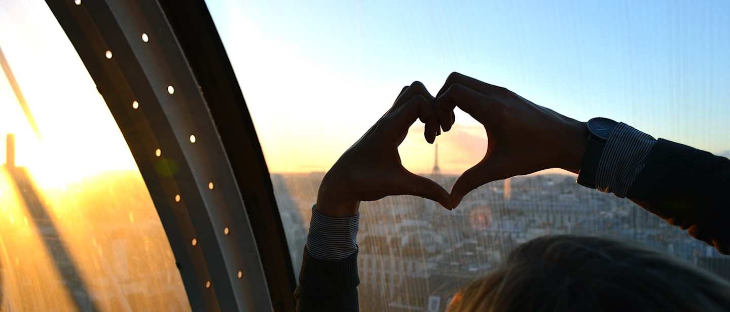 Person shaping a heart with their hands in Paris