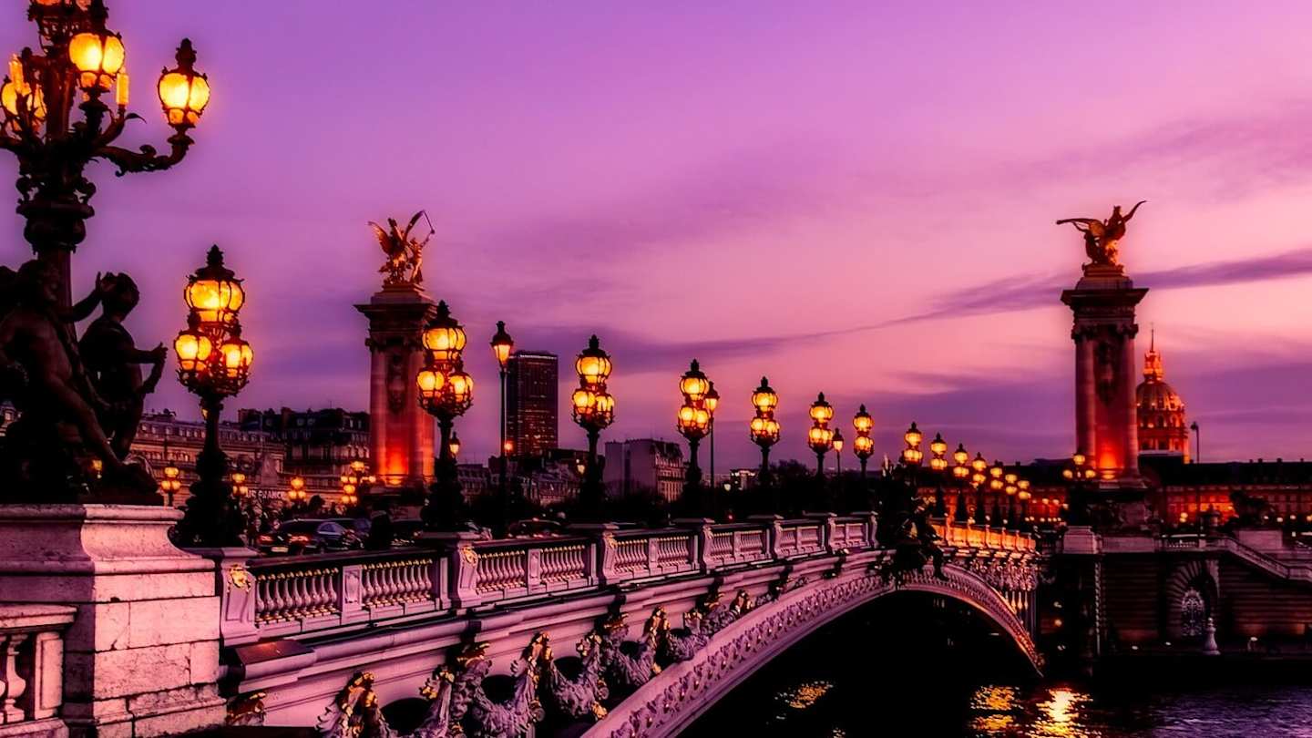 Bridge in Paris lit up at sunset