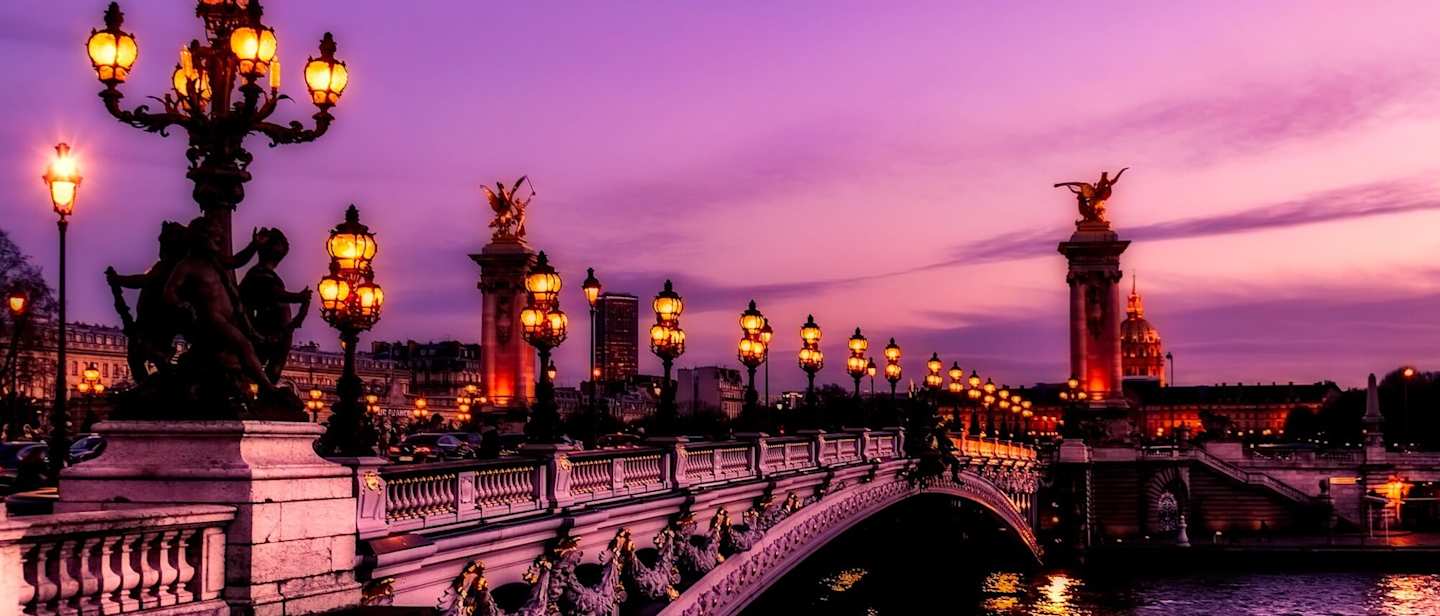 Bridge in Paris lit up at sunset