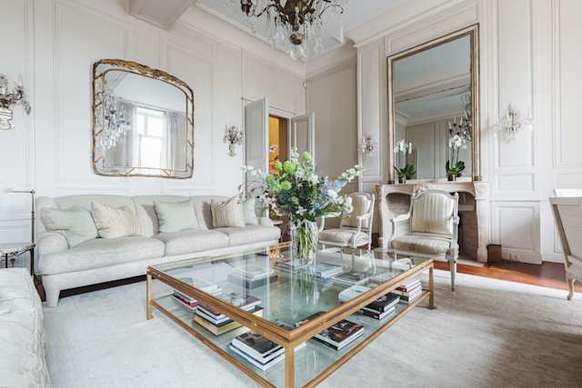 Glass coffee table with books in the living room of Le Palais de Marie, Plum Guide home in Paris