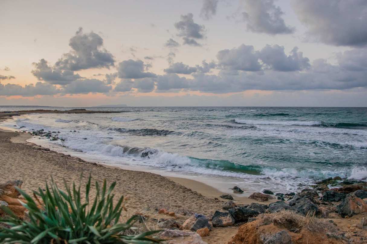 Waves crashing onto the sand at a beach in Malia at sunset, Crete, Greece