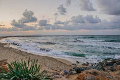 Waves crashing onto the sand at a beach in Malia at sunset, Crete, Greece