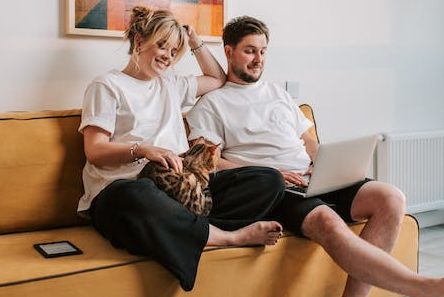 People sat on sofa with a cat