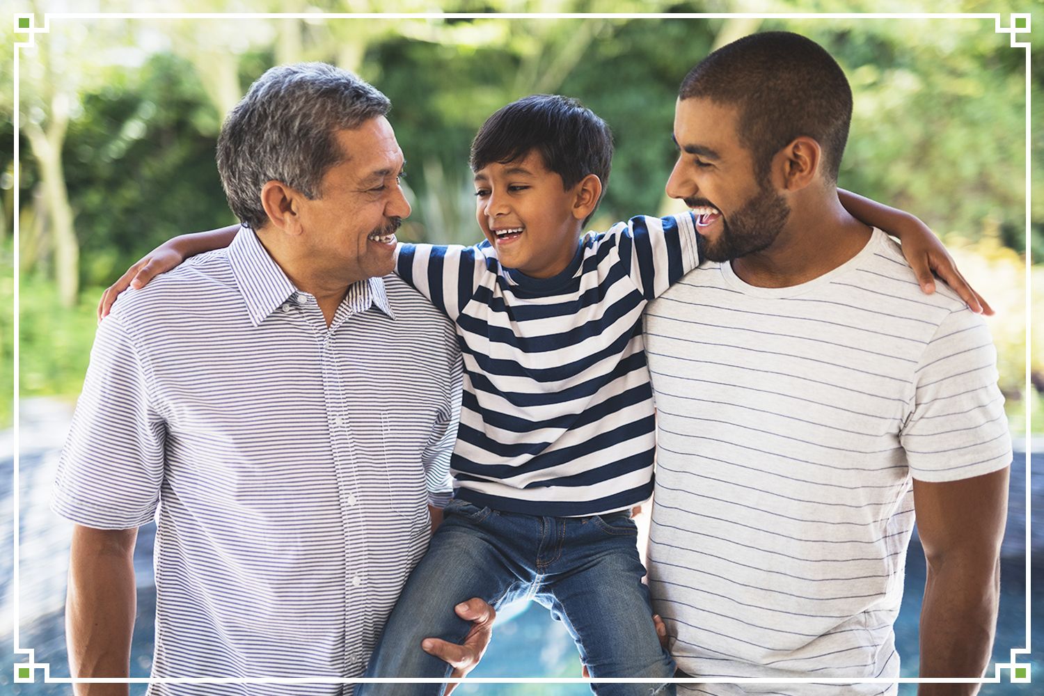father and grandfather holding young boy, laughing